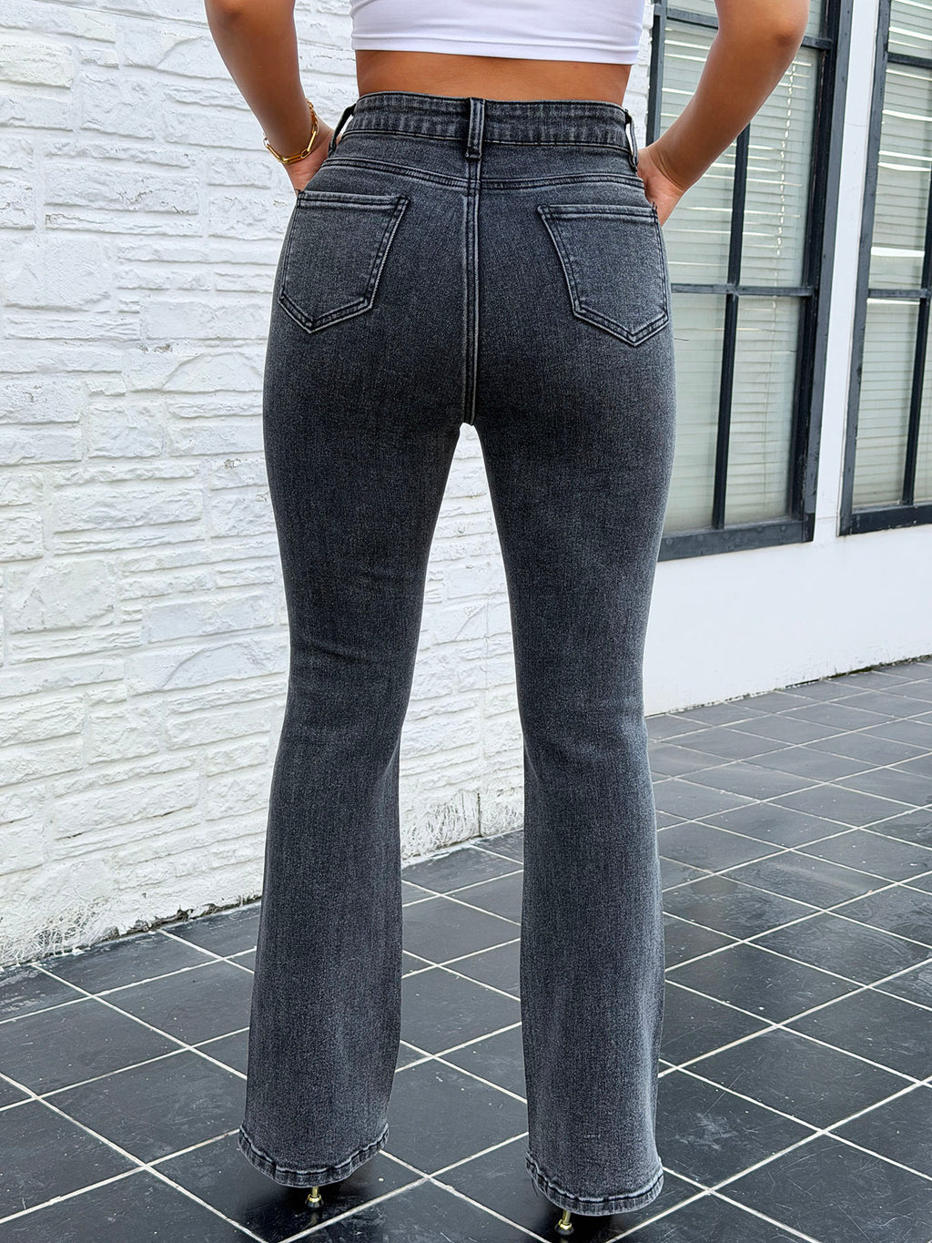 Close up of striped rhinestone details on vintage dark wash stretch flare jeans for women – butt lifting denim pants decoration shot