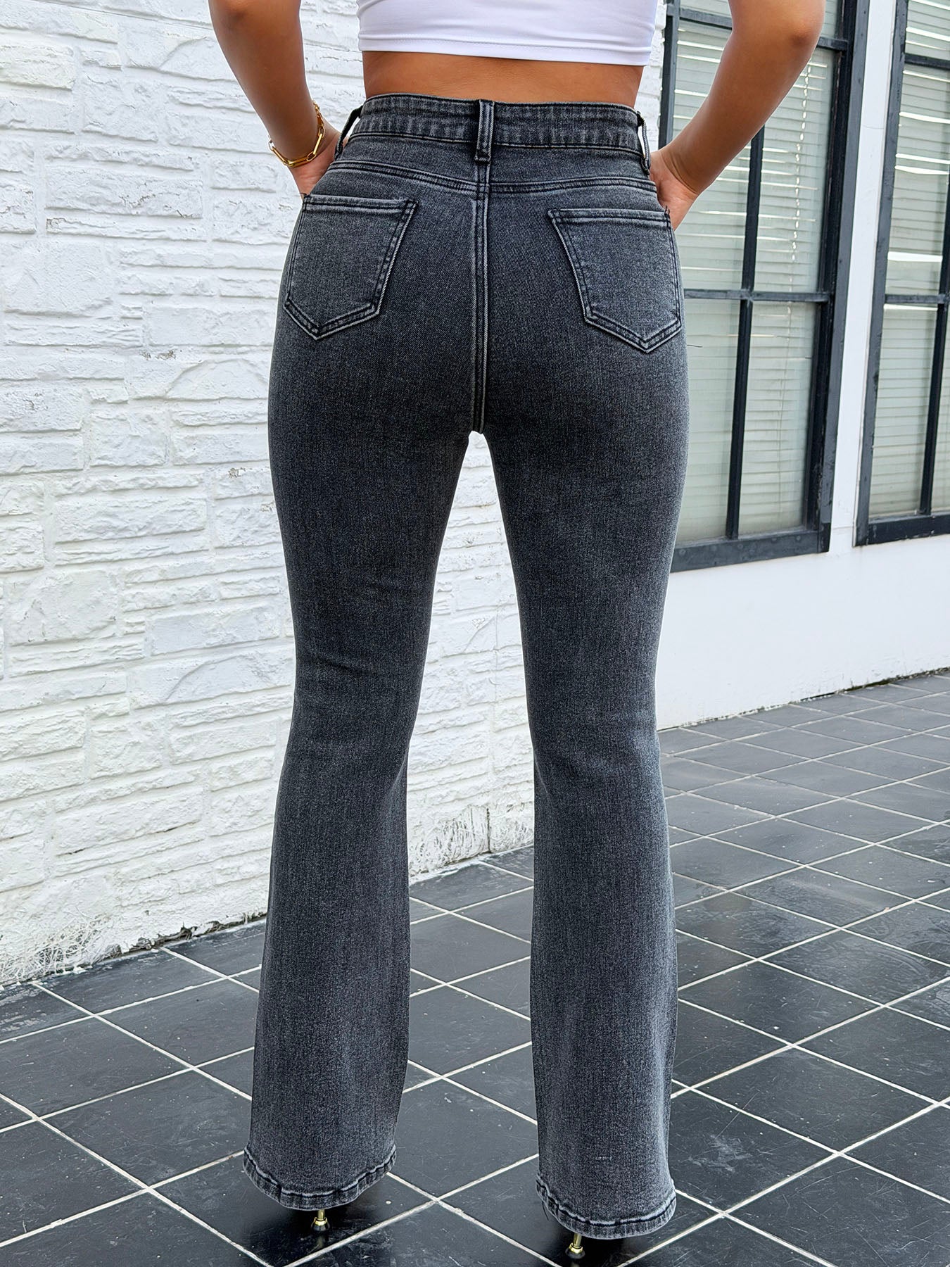 Close up of striped rhinestone details on vintage dark wash stretch flare jeans for women – butt lifting denim pants decoration shot