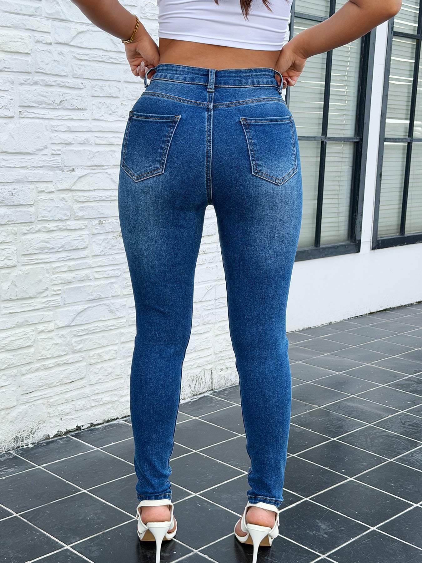 Sparkly skinny jeans with heart embroidery – back view of stretchy sexy rhinestone blue denim pants showing fit on model