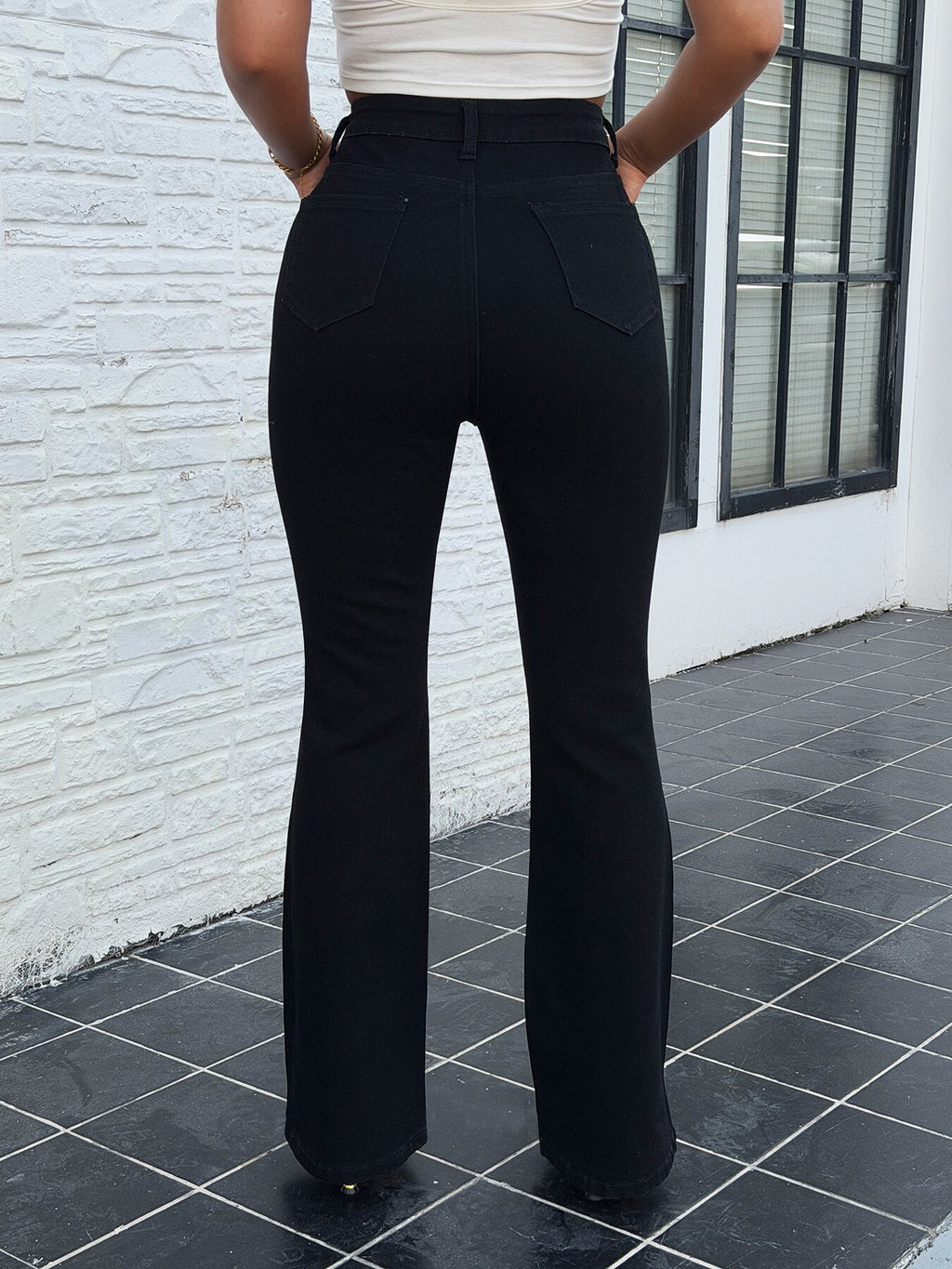 Vintage bootcut jeans with white rose embroidery – side view of stretch flare denim pants for women showing slim fit silhouette on model