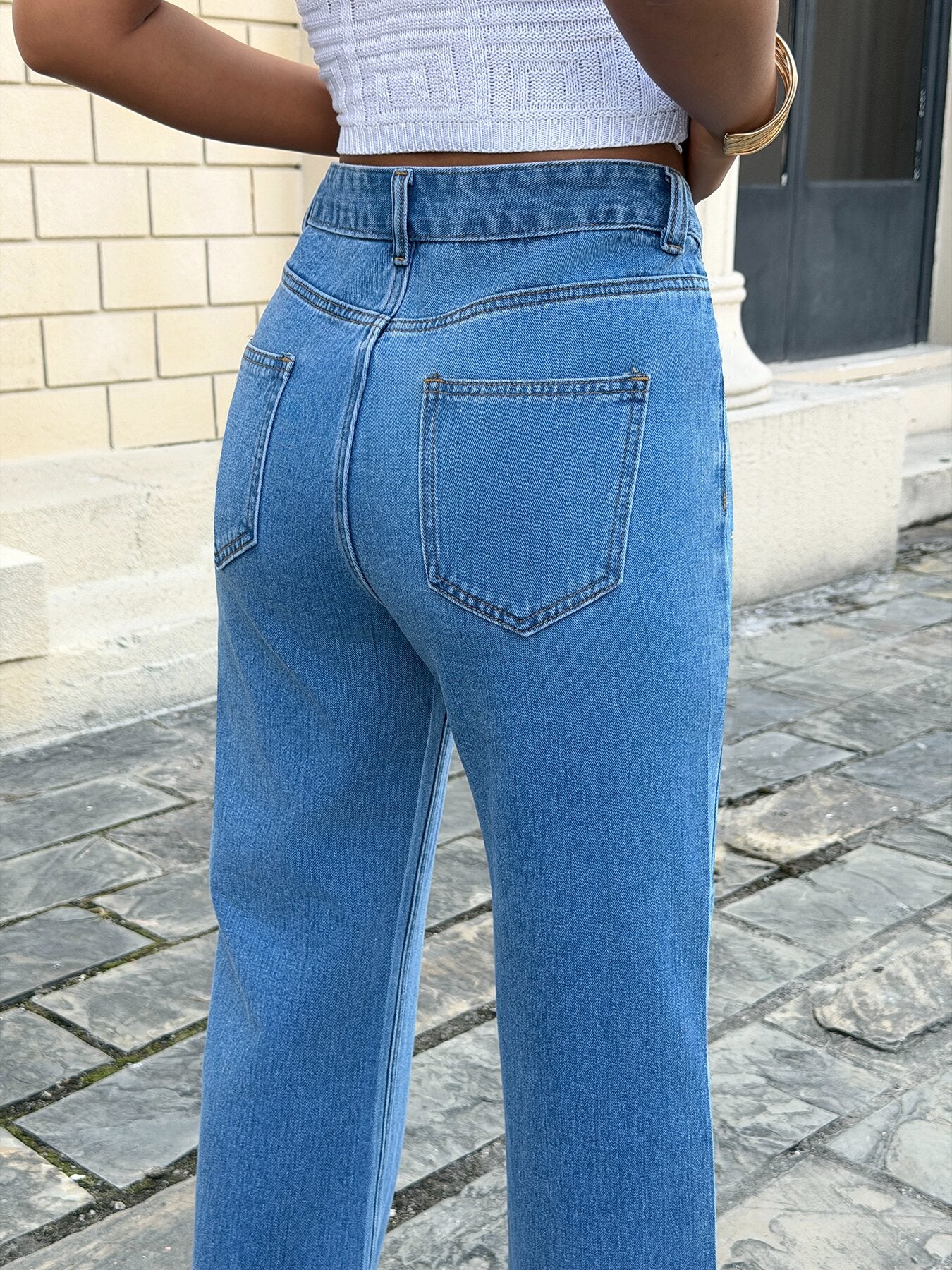 Flat lay of embroidered wide leg jeans for women – classic blue loose fit straight leg denim pants with rhinestone details on white background