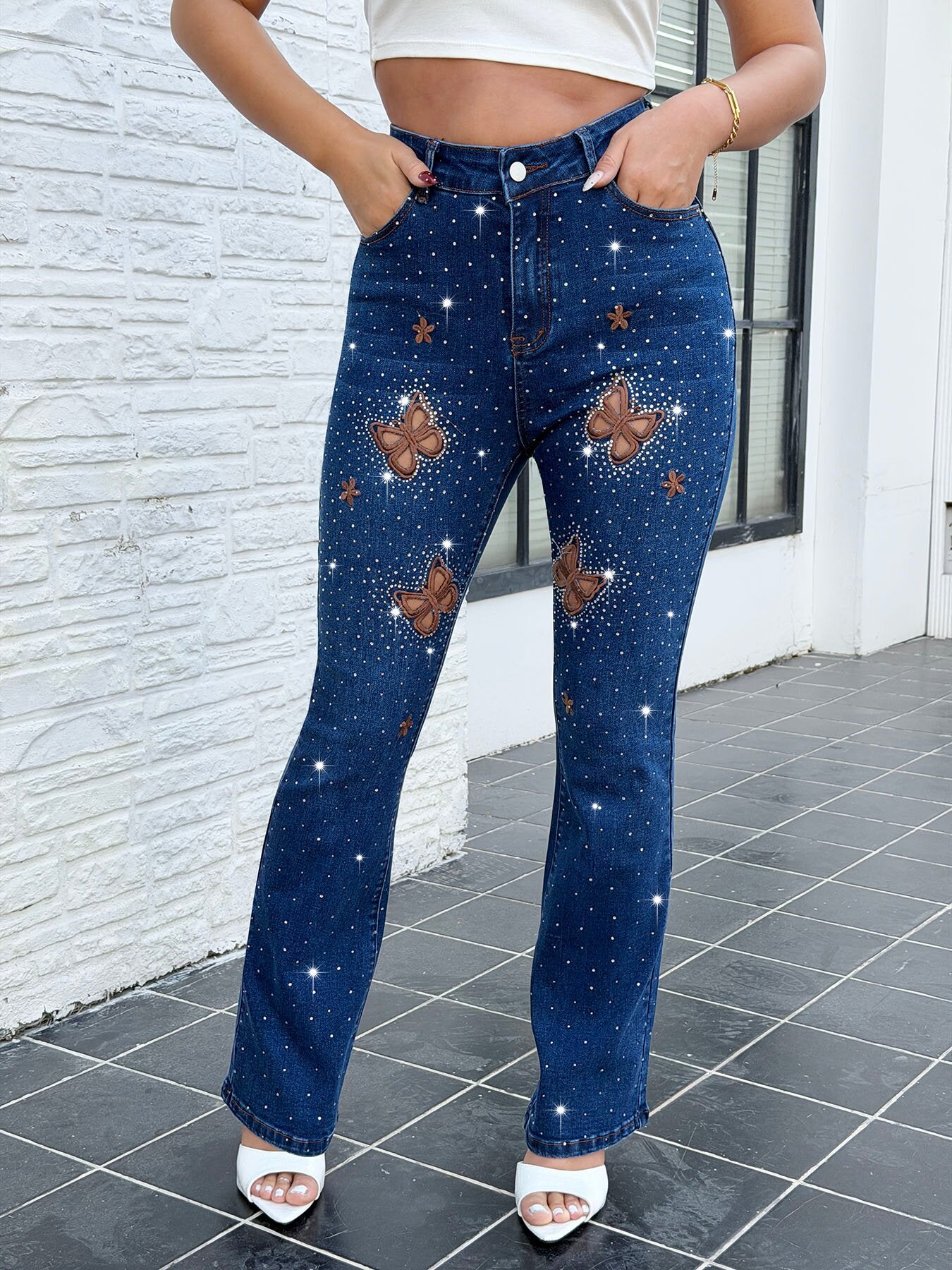 Styled butterfly cutout rhinestone jeans for women – party ready sparkle embroidered dark blue bootcut denim pants with sequin top and heels night out outfit