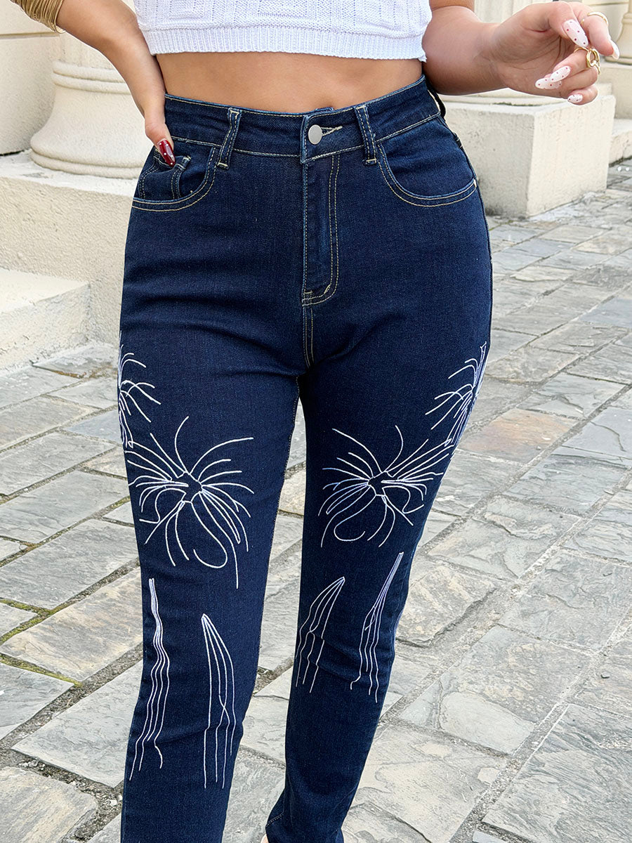 Close up of vintage white embroidery and stretch denim fabric on dark blue skinny jeans for women – butt lifting pants detail